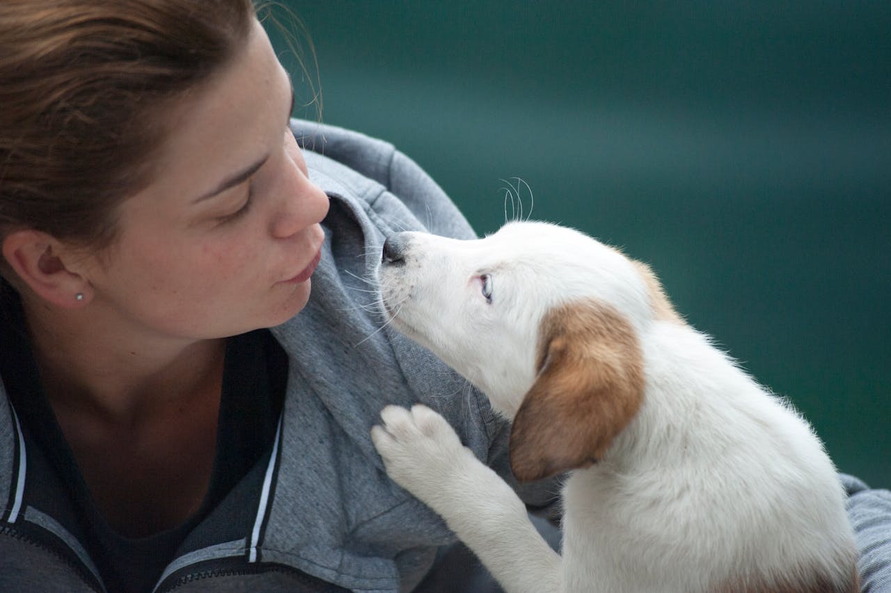 hero-img-02 A candid shot of a woman and puppy sharing a tender moment outdoors.